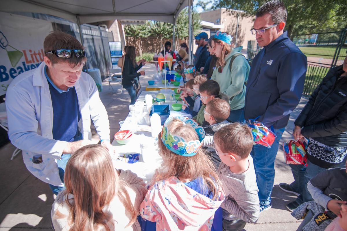 Scientist shows kids an experiment at The Cynthia Woods Mitchell Pavilion's Children's Festival in The Woodlands, Texas