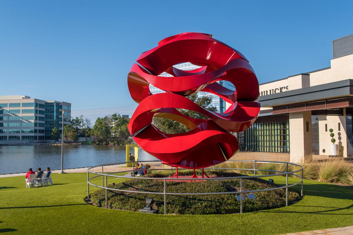 red wavy public art feature in front of the lake