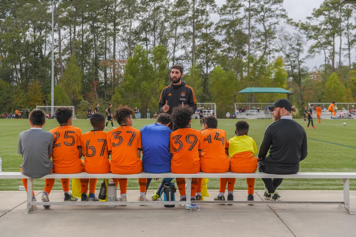 Coach talking to young soccer players during COPA Rayados International Cup in The Woodlands, Texas