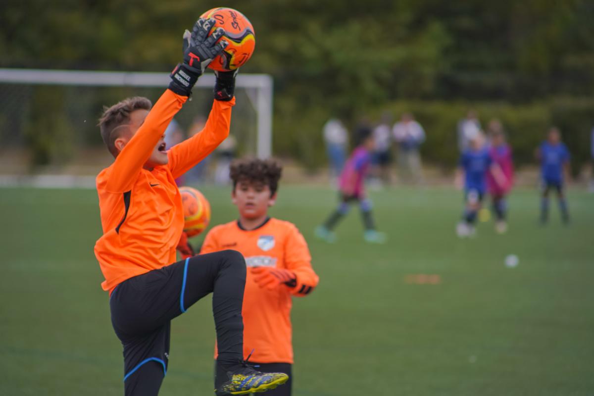 Young soccer player catches ball during COPA Rayados International Tournament in The Woodlands, Texas