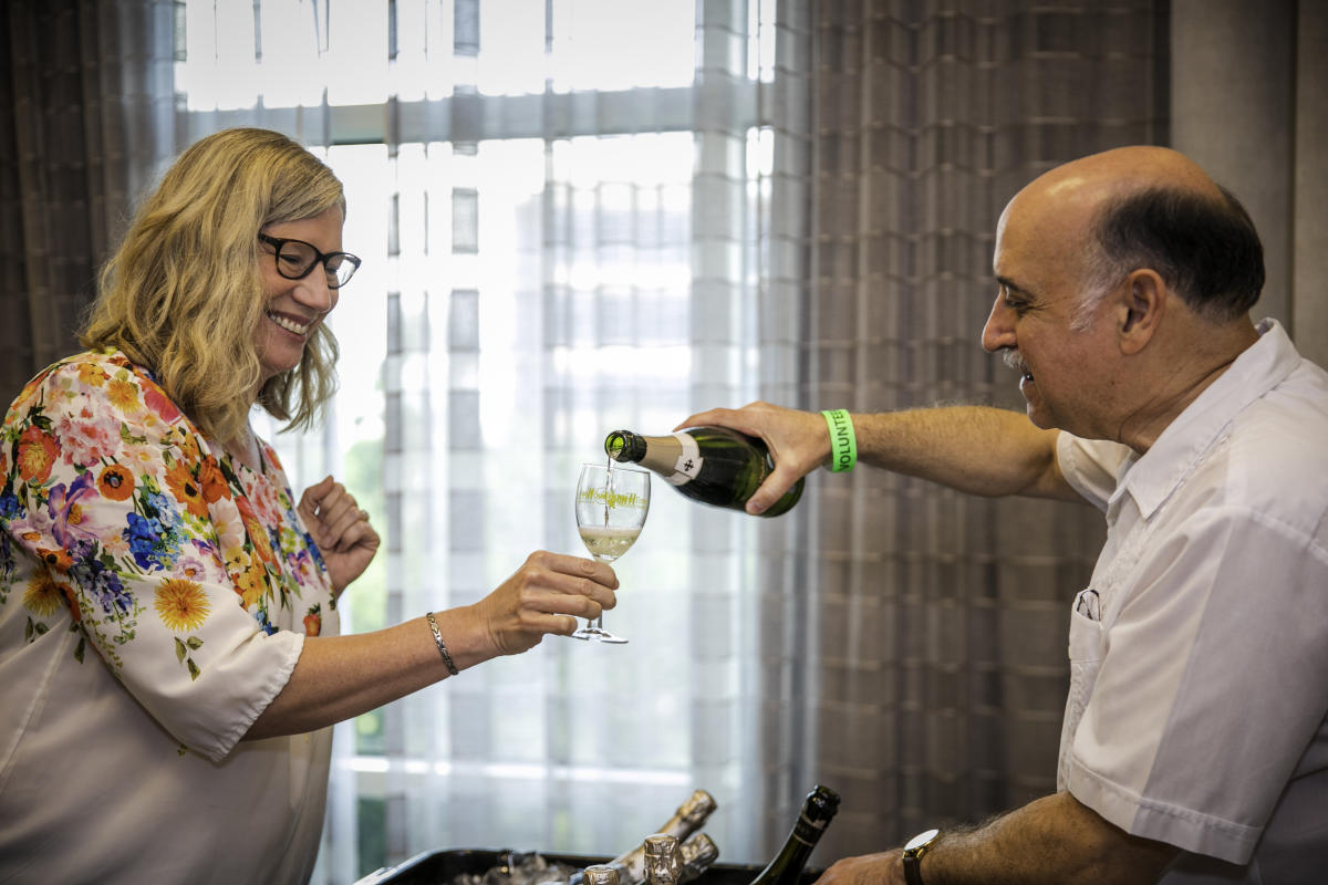 Volunteer pouring wine at Wine Around The World during Wine & Food Week in The Woodlands