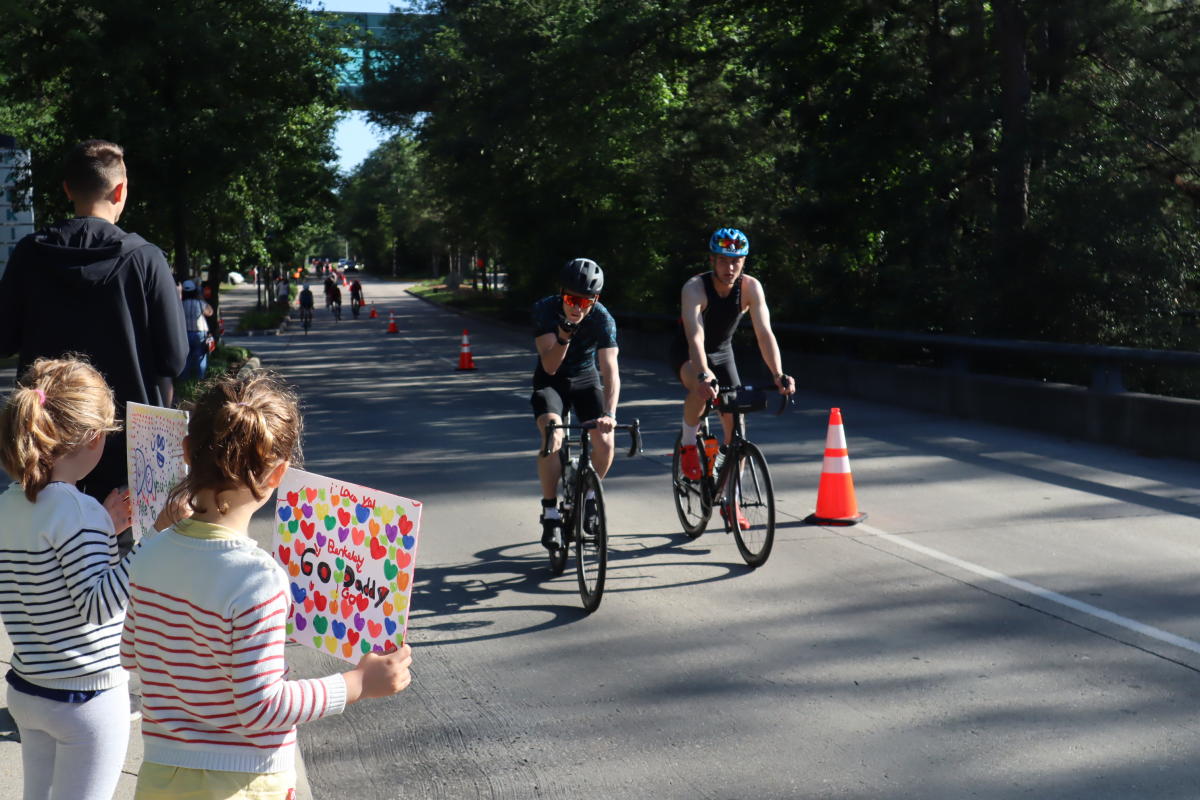 Young girl holding sign up to cheer on her dad at IRONMAN Texas in The Woodlands, Texas
