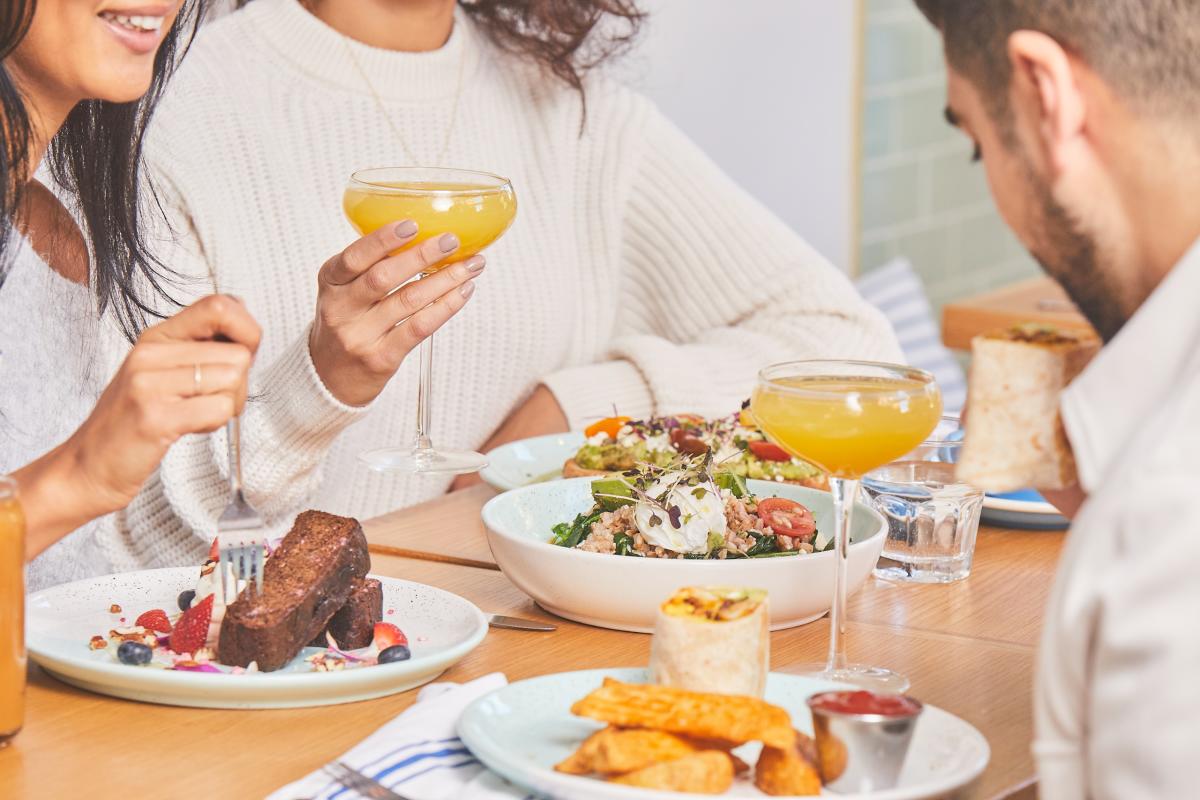 People eating breakfast and enjoying mimosas at Bluestone Lane in The Woodlands, Texas
