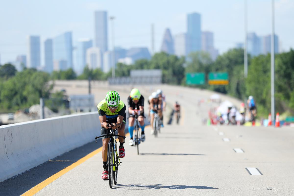 People biking along the Hardy Toll Road during IRONMAN in The Woodlands, Texas