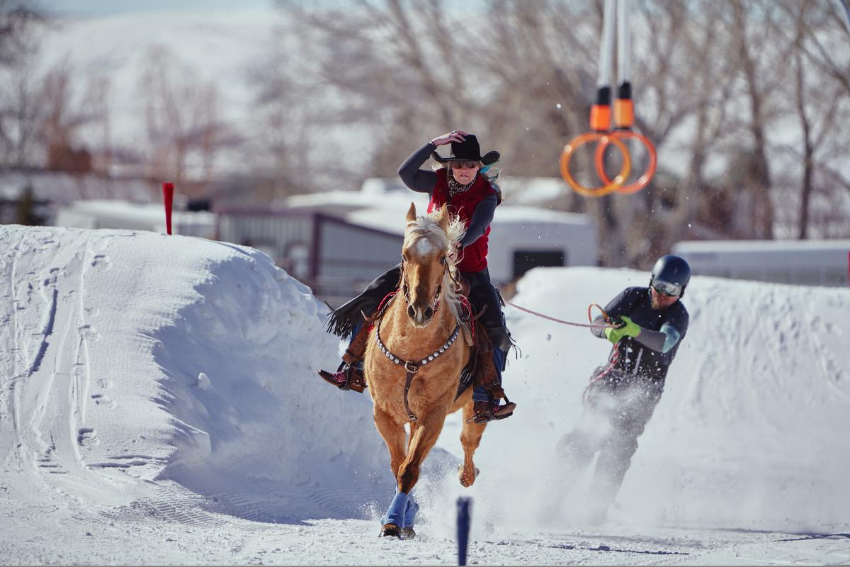 A cowboy on horse is pulling a rider on skis in Pinedale, Wyoming, for it's annual skijoring compeition.