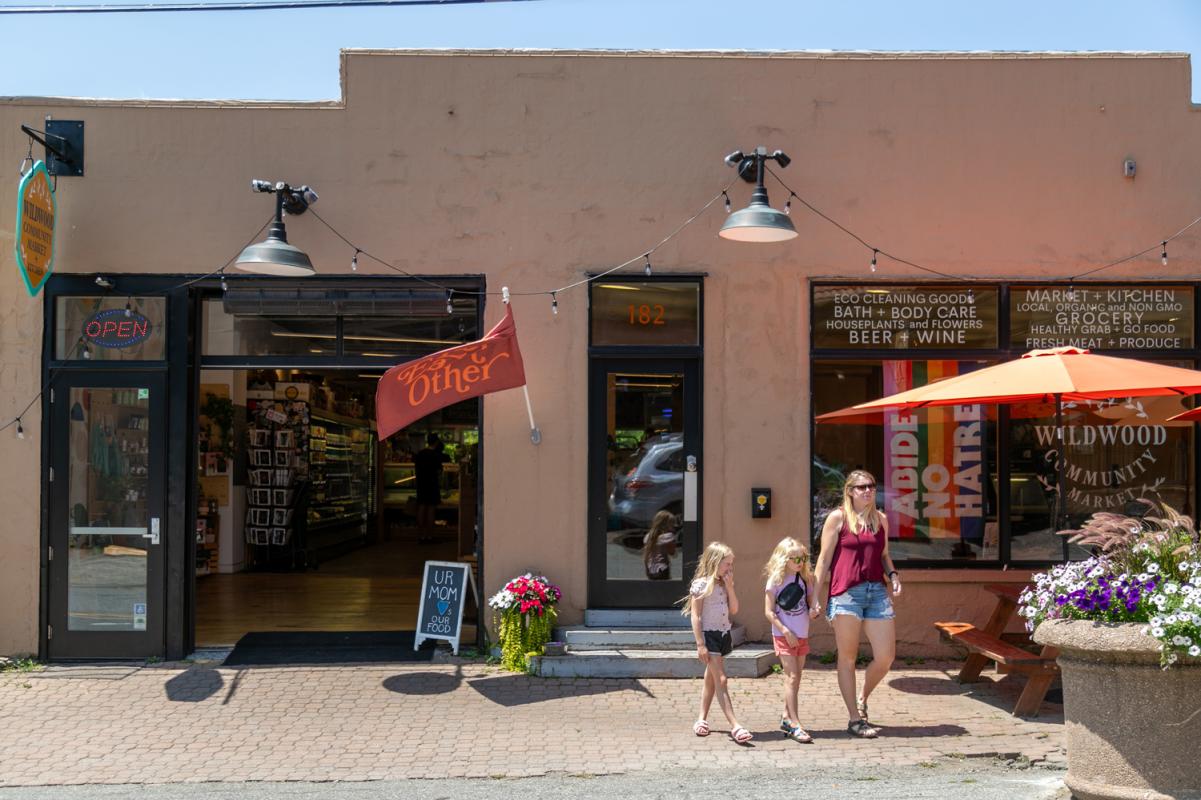 A woman with two young girls are shown exiting Wildwood Community Market.