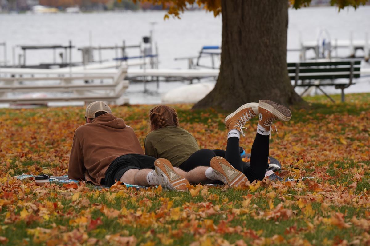 Couple relaxing by the lake in autumn