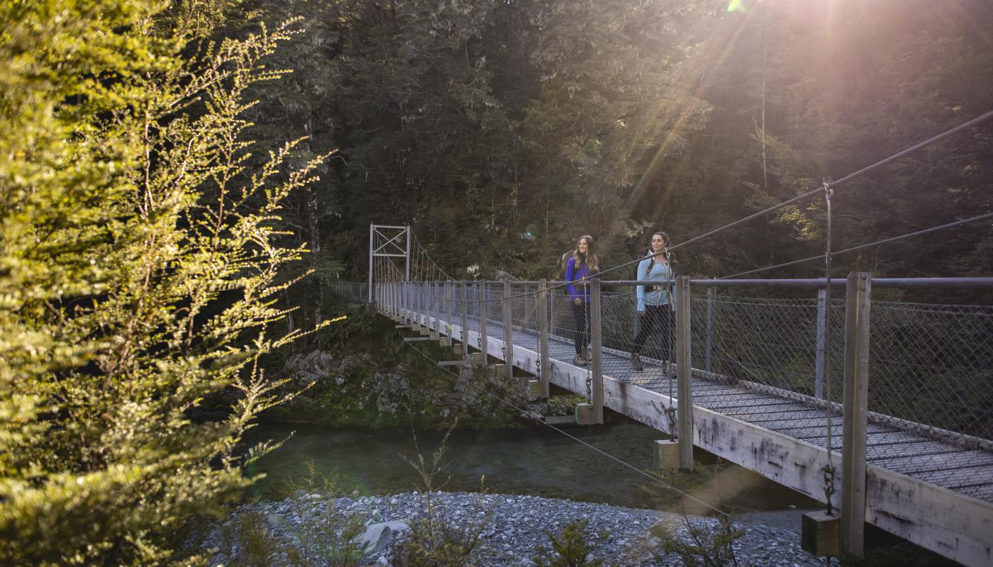 Two female hikers on the Routeburn Track swing bridge