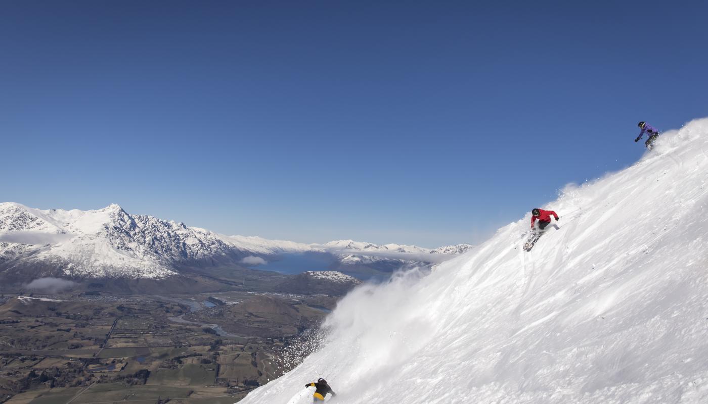 Friends skiing Coronet Peak on a bluebird day