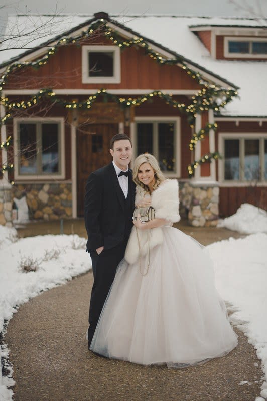 A couple poses during a winter wedding