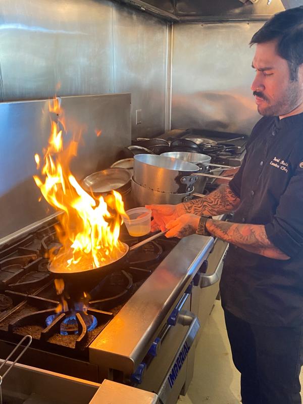 Scalo Executive Chef David Ruiz flambes something in a frying pan