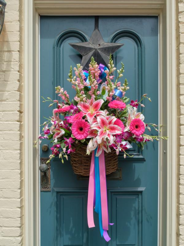 Teal blue door with pink and white vibrant flowers hanging