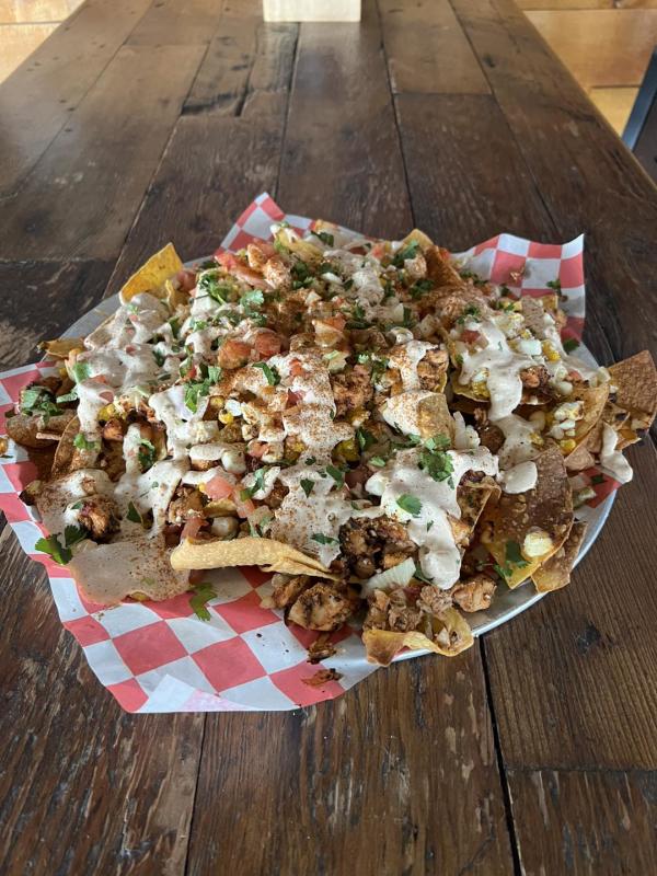 Large plate of nachos with several mexican inspired toppings