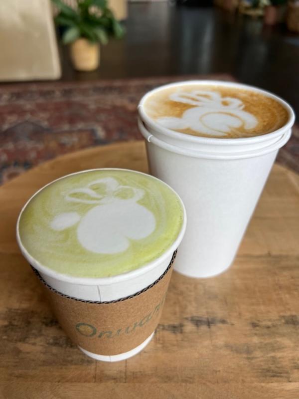 Two white cups of coffee with latte art on the top on a table