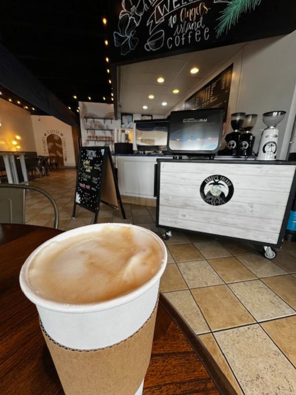 White paper cup of coffee with cafe counter in the background at Angels Island