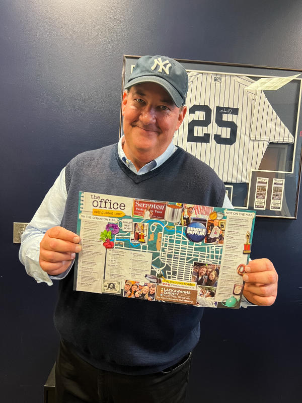 Brian Baumgartner (aka Kevin from The Office tv show) holding The Office Self-Guided Tour map