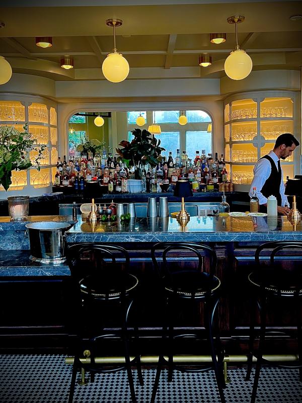 Bartender preparing drinks at the marble bar inside Brasserie Royale in Sterling, Loudoun County