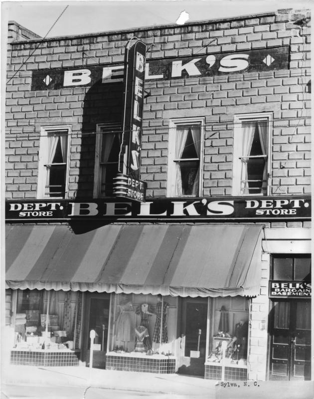Brick front of Belk’s Department Store on Main Street in Sylva, NC, in the 1940s, with a vertical sign, striped awning and Bargain Basement entrance