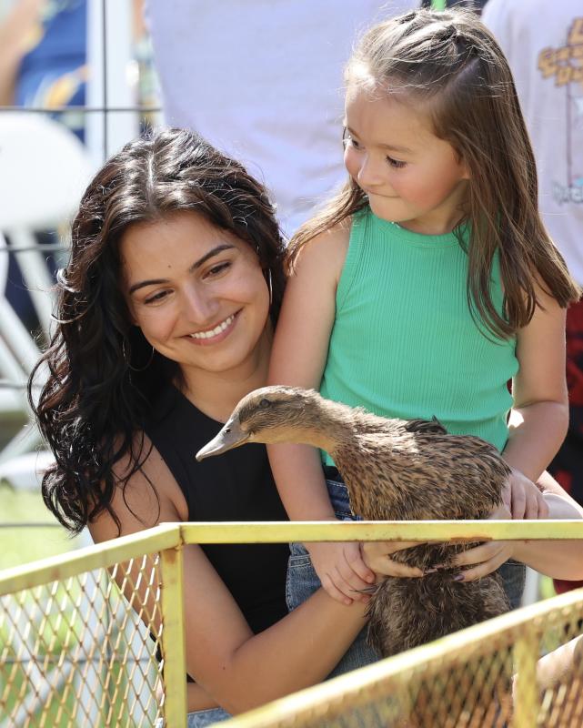 A woman and little girl hold a duck