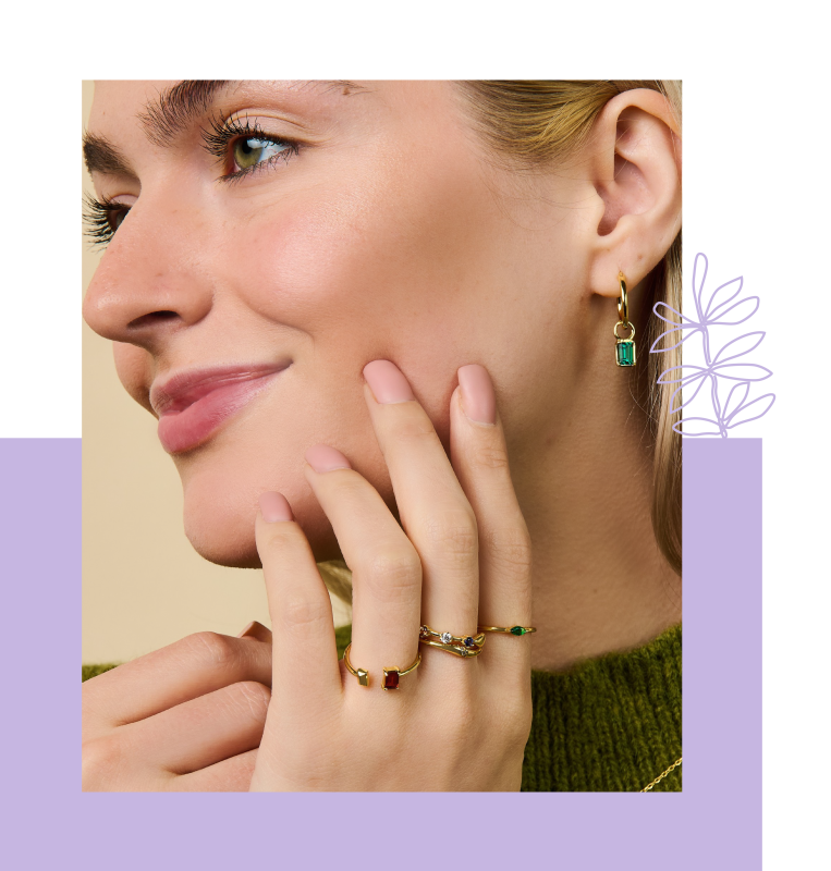 Woman wearing rings and earrings with birthstones