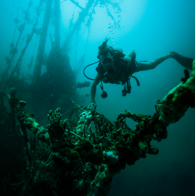 A man dive into the ruins of the old wreck