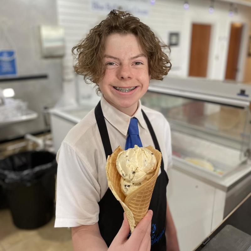 A Pop's Soda Shoppe employee holds an ice cream cone.