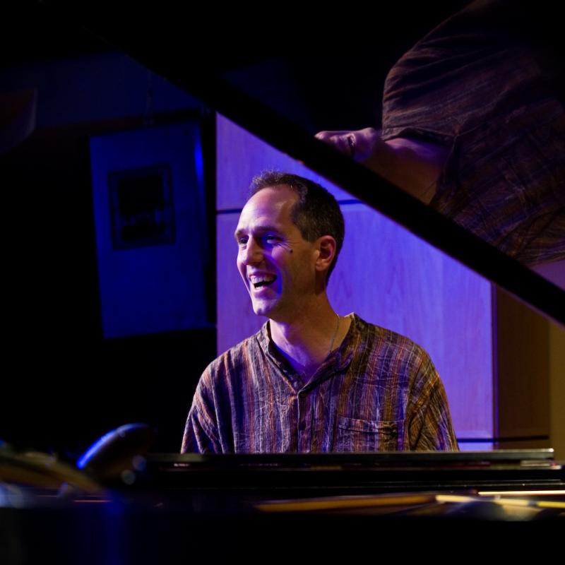 A man sits at a piano at QBar Lounge in Hotel Albuquerque