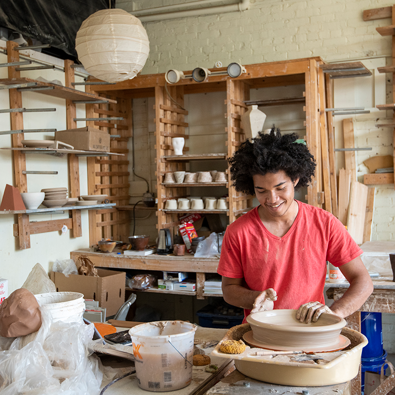 Person throwing a pot on a pottery wheel