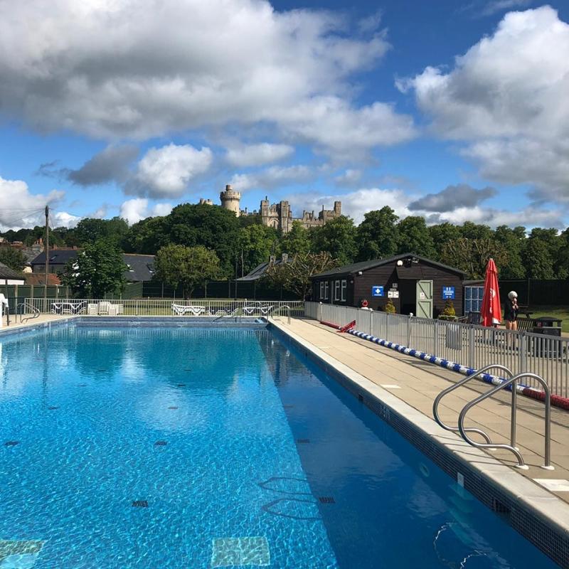 A picture showing a swimming pool with a castle in the background