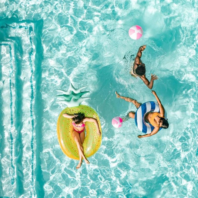 Bird's-eye view of people playing in the pool with colorful floaties at Hotel ZaZa Memorial City in Houston.