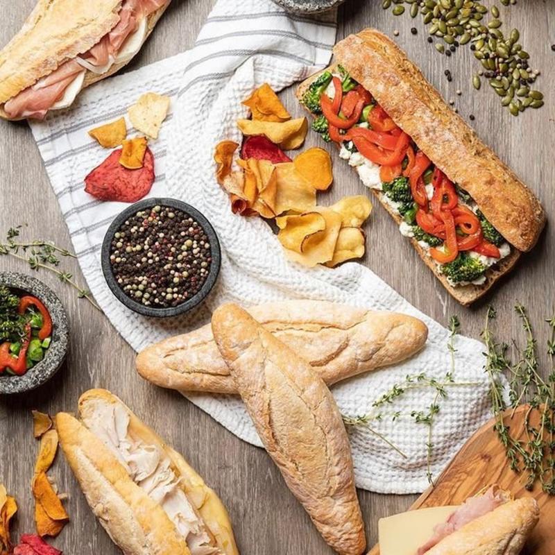 assorted bread and sandwich items on a towel from a bakery