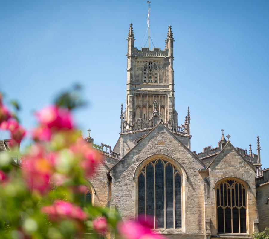 Cirencester in the summer, The church against a blue sky and pink flowers