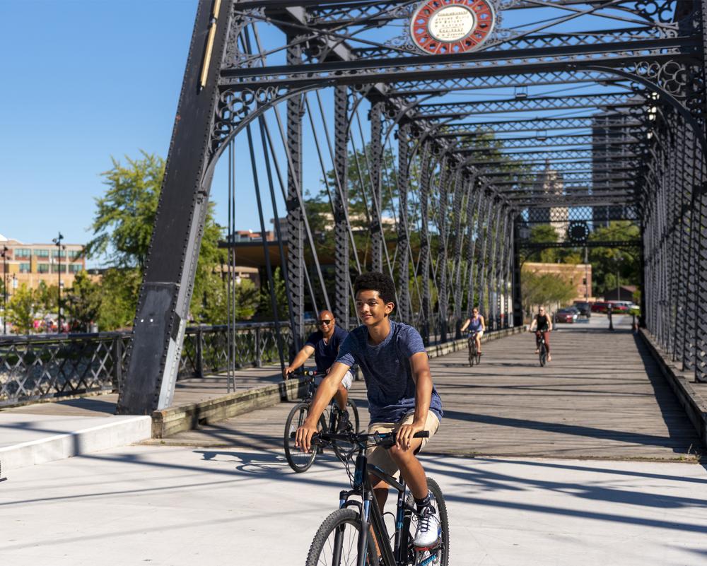 Family biking across the wells street bridge at promenade park