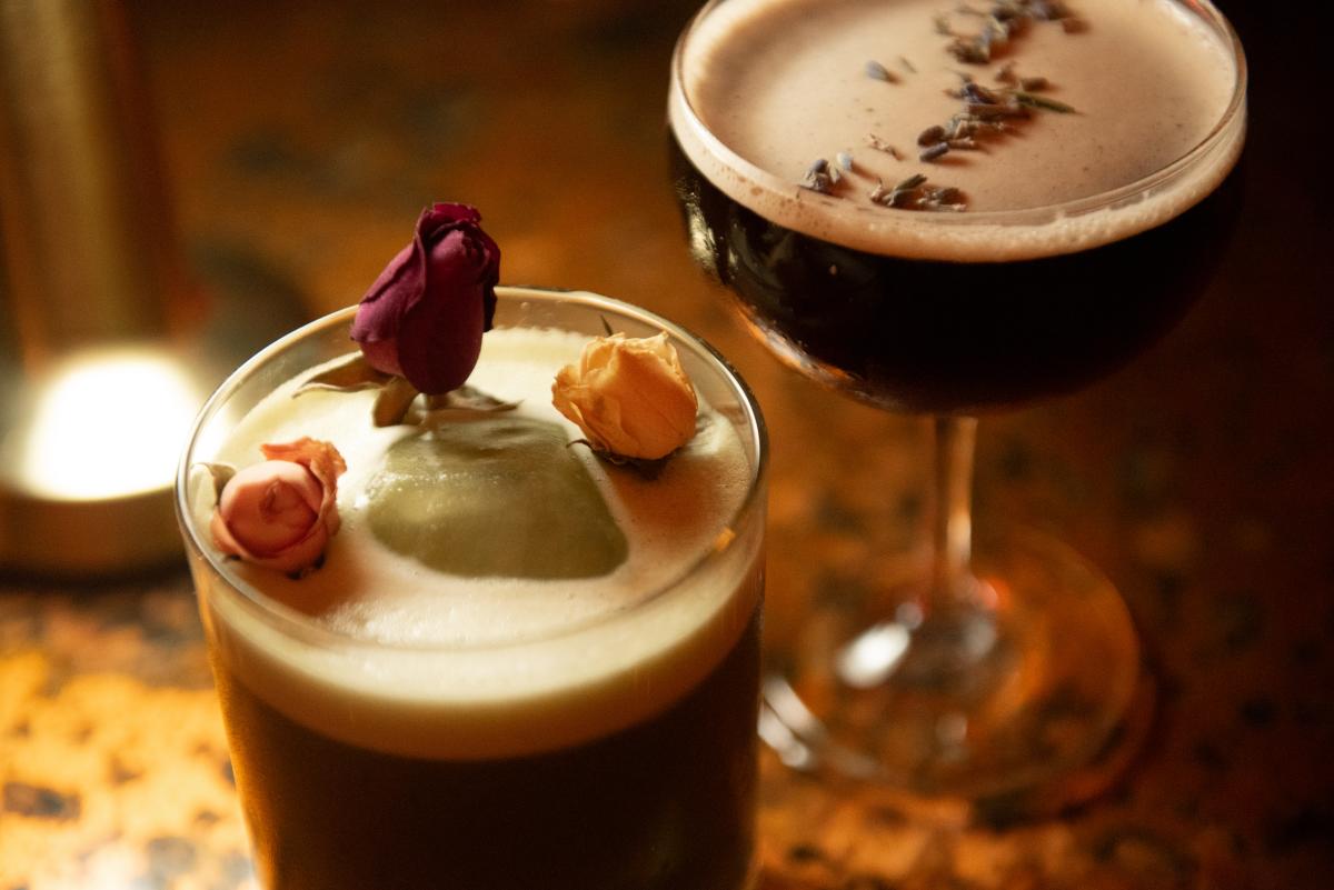 Two drinks with floral garnishes at Copacetic Cowboy.