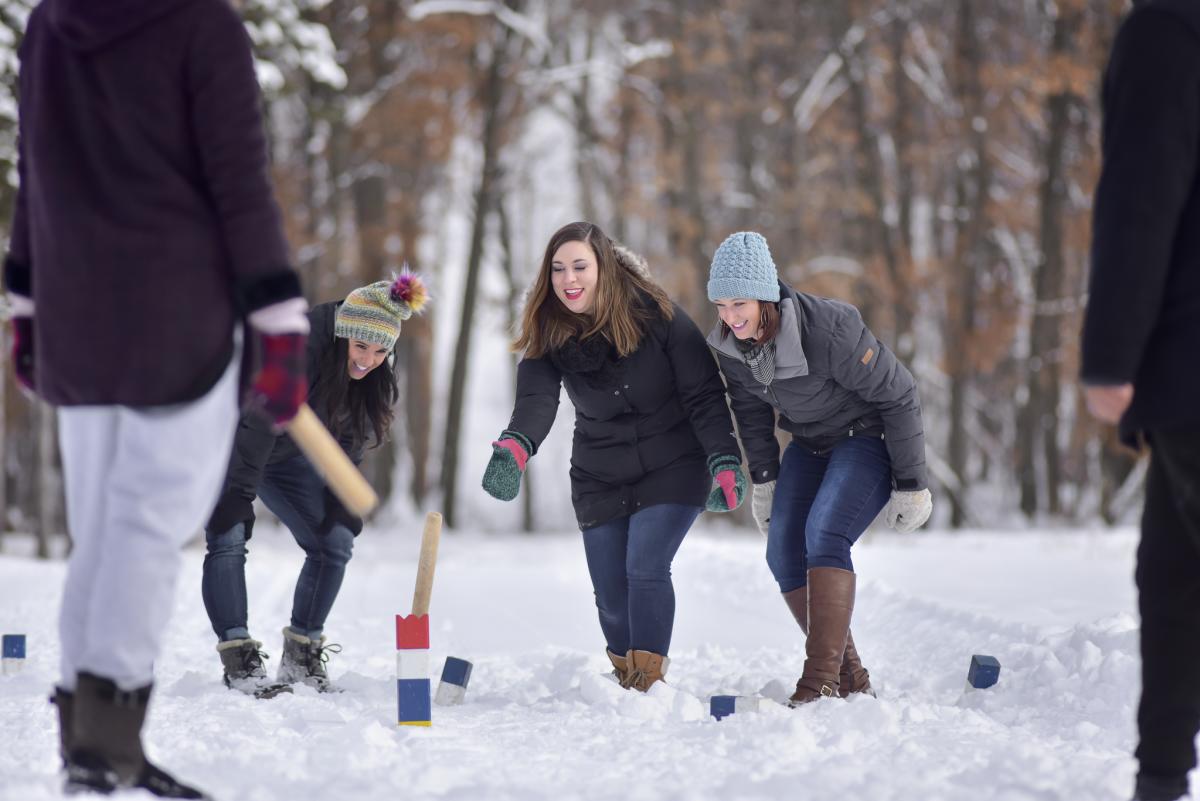 A group of people playing Kubb in the winter at Pinehurst Park