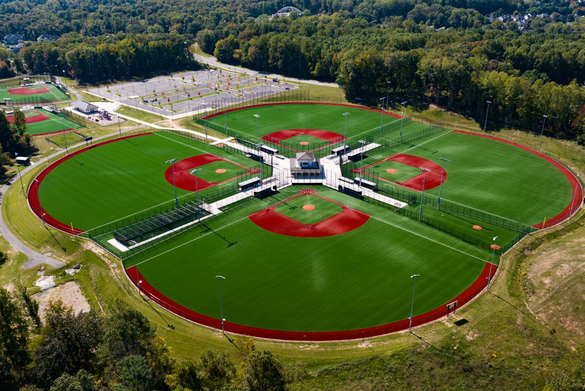 5 diamond fields at night with field lights on showcasing the baseball/softball setups.