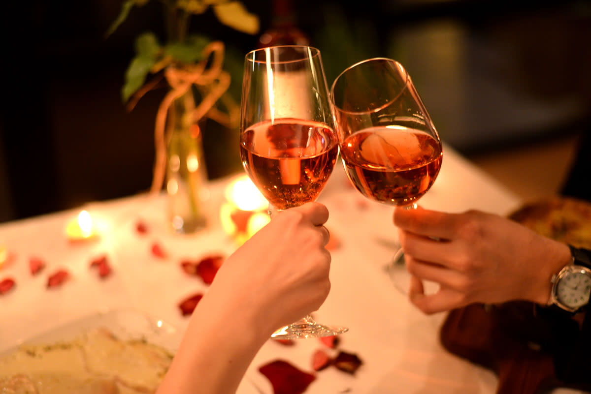 Romantic gift guide for Finger Lakes Wine Country and a couple toasting over wine at a romantic dinner for two