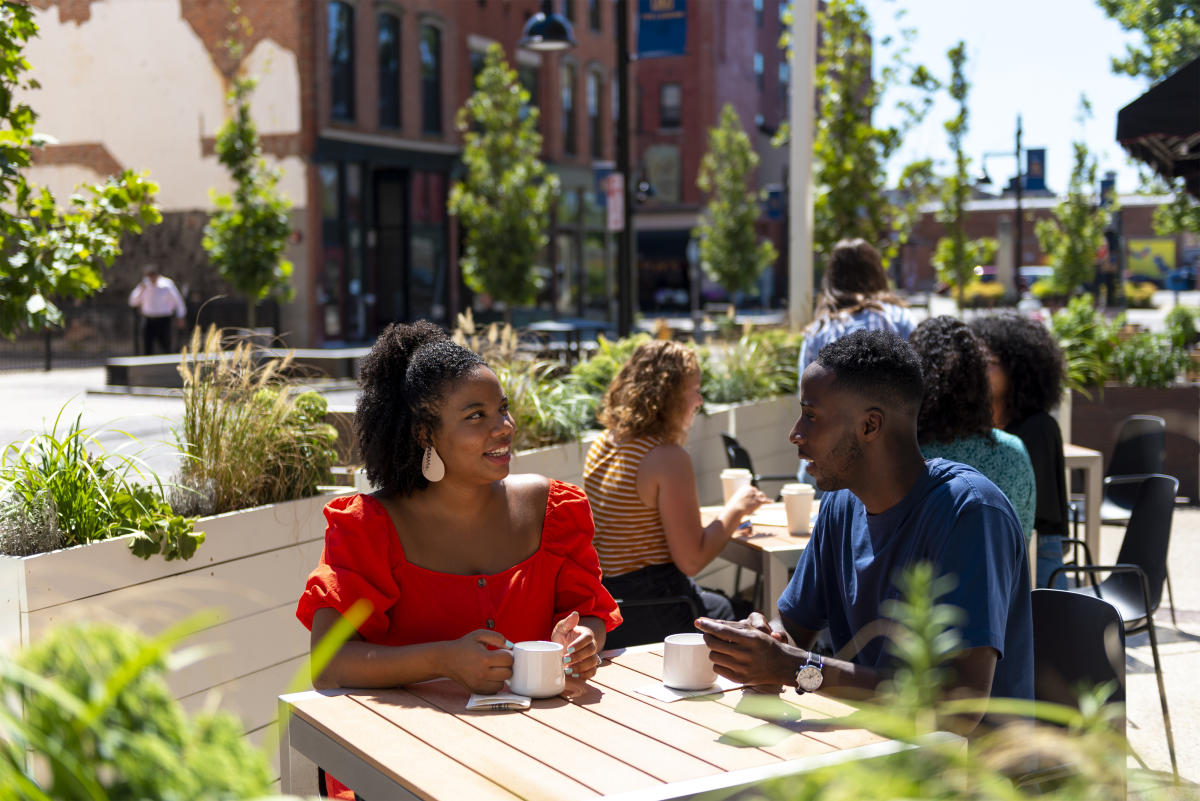 A couple dining outdoors at Utopian Coffee on The Landing in Fort Wayne, Indiana