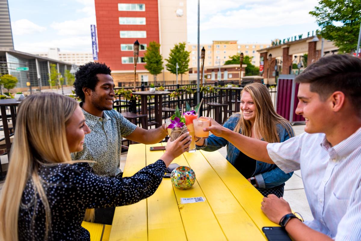 Young adults enjoying drinks at the Sidecar outdoor bar in downtown Fort Wayne.