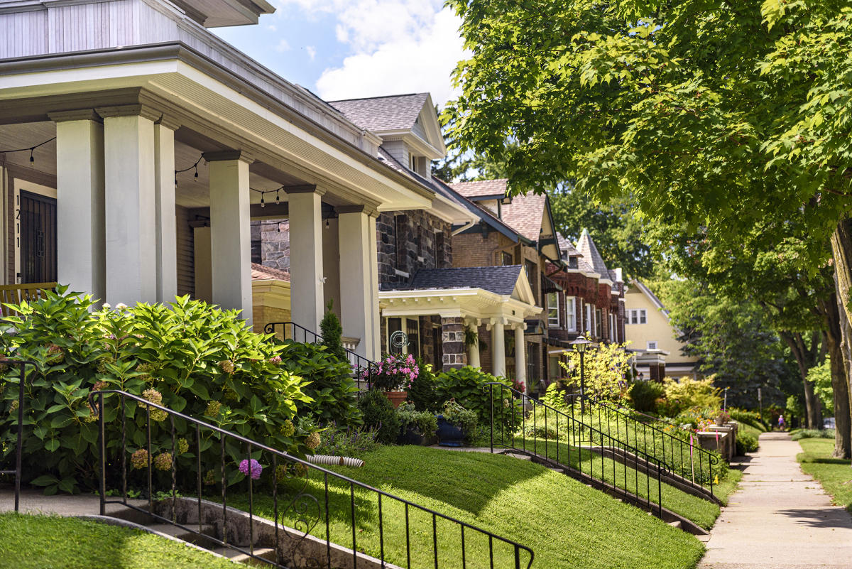 a row of historic homes with a sidewalk running along the front