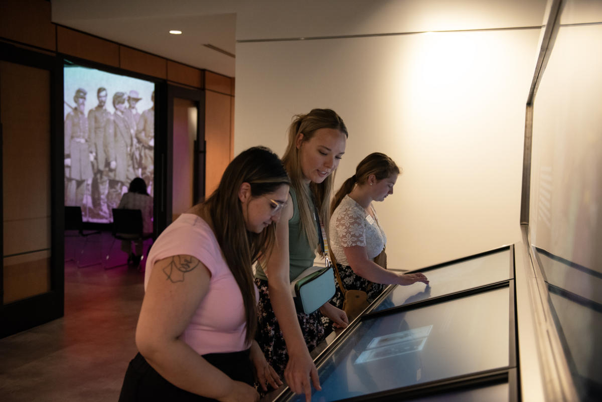 Women navigating a digital kiosk about Abraham Lincoln