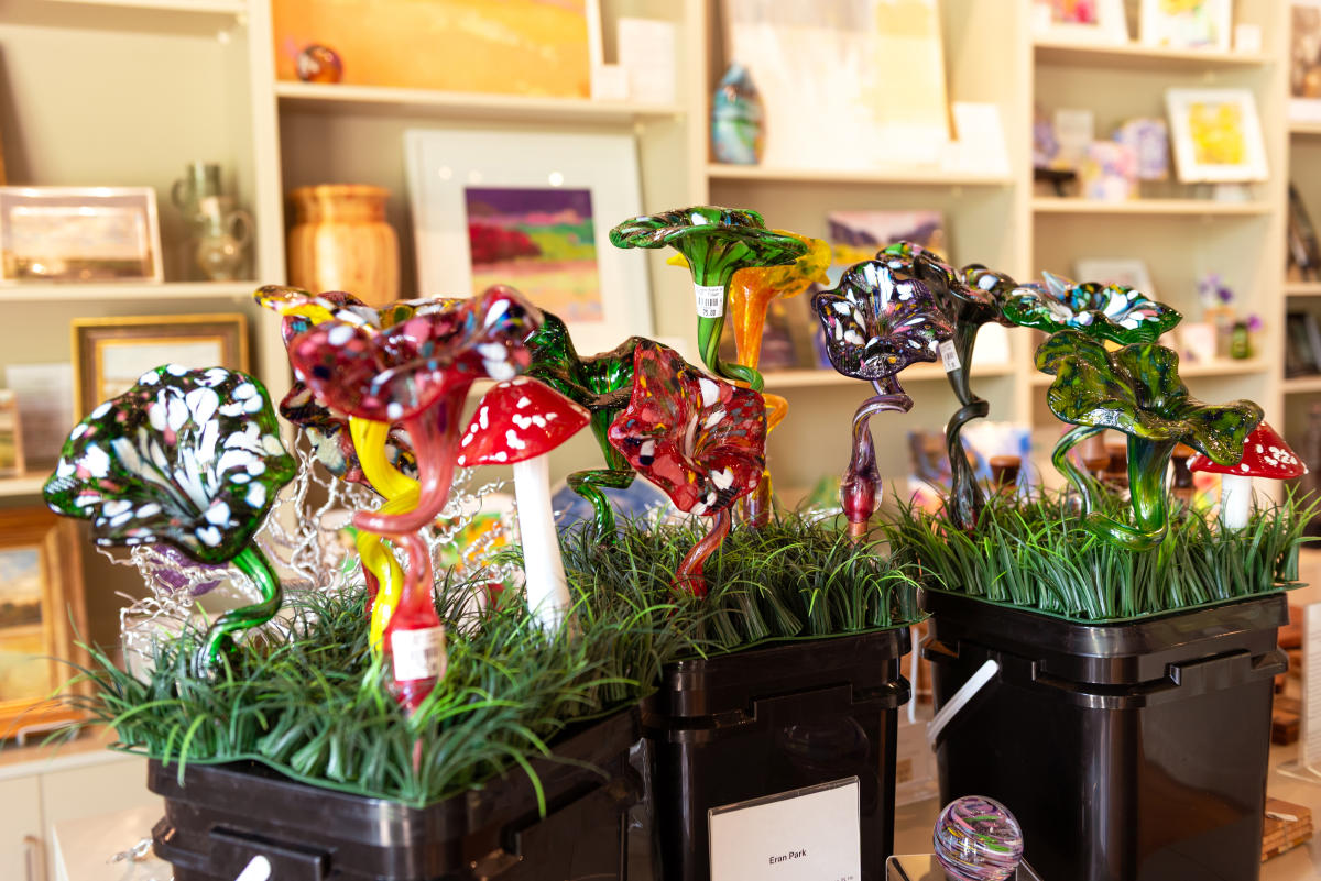 display of colorful blown glass flowers and mushrooms for sale in the Paradigm Gallery gift shop at the Fort Wayne Museum of Art