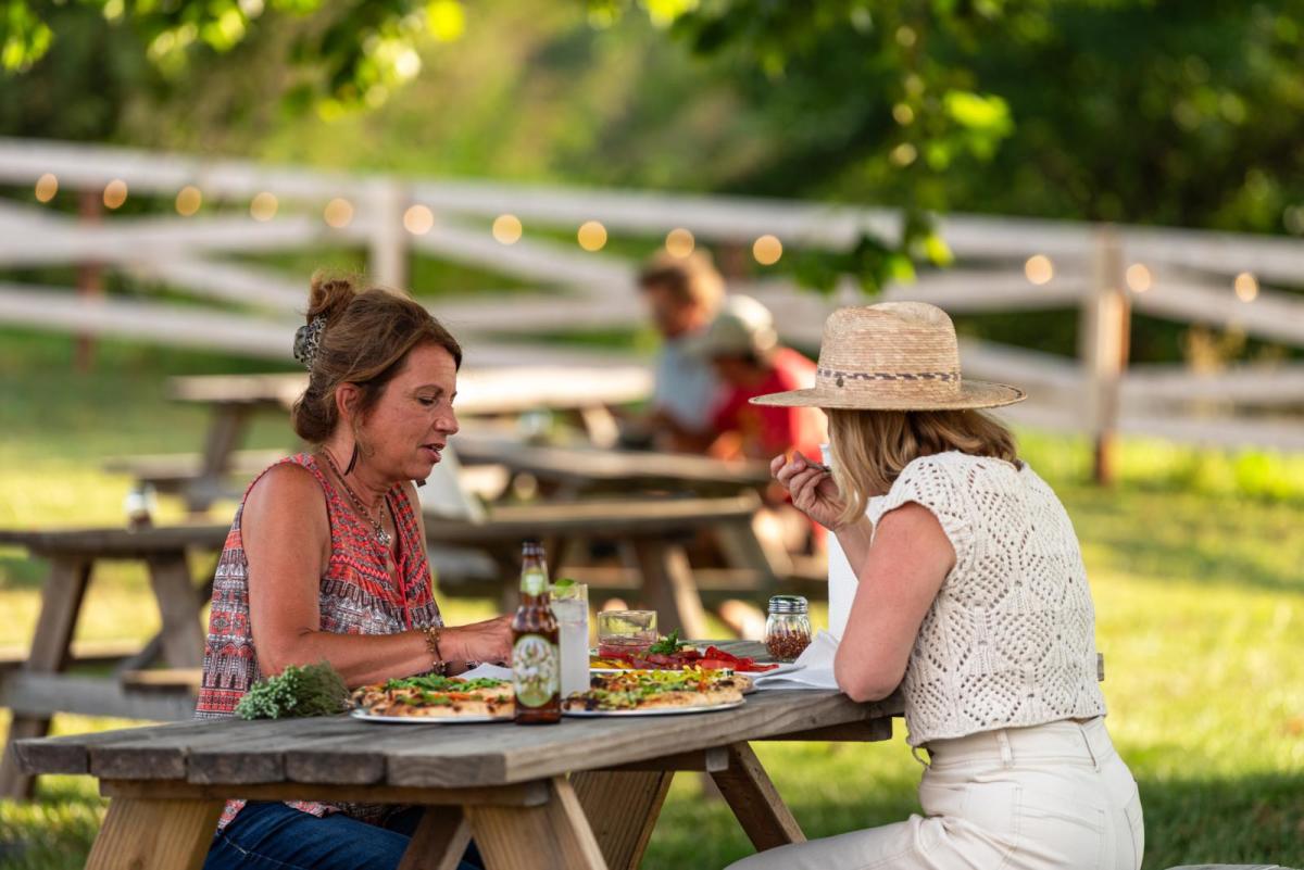 Two friends eat at Juniper Hill Farm near Lawrence, KS