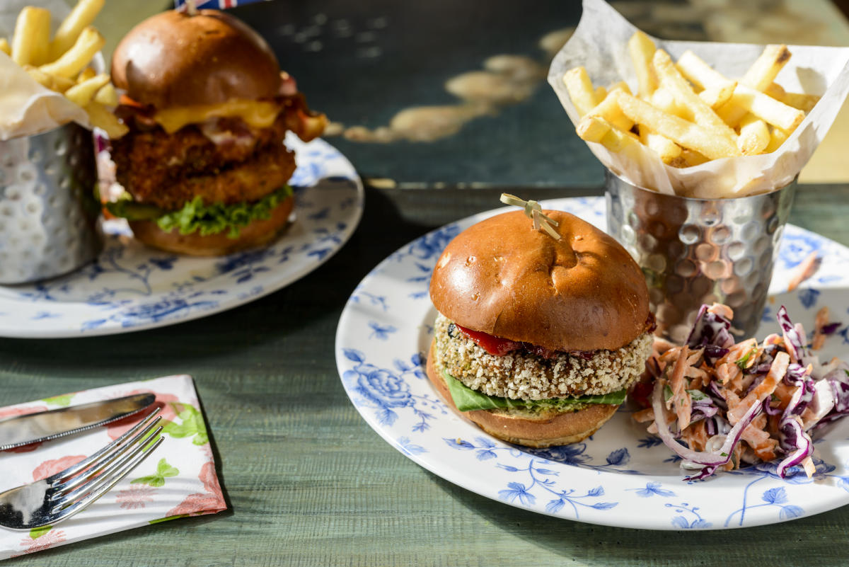 A vegan burger meal presented on a table next to a chicken burger meal