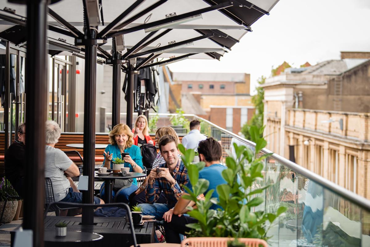 a group of people dining at Everyman Cinema's outdoor balcony