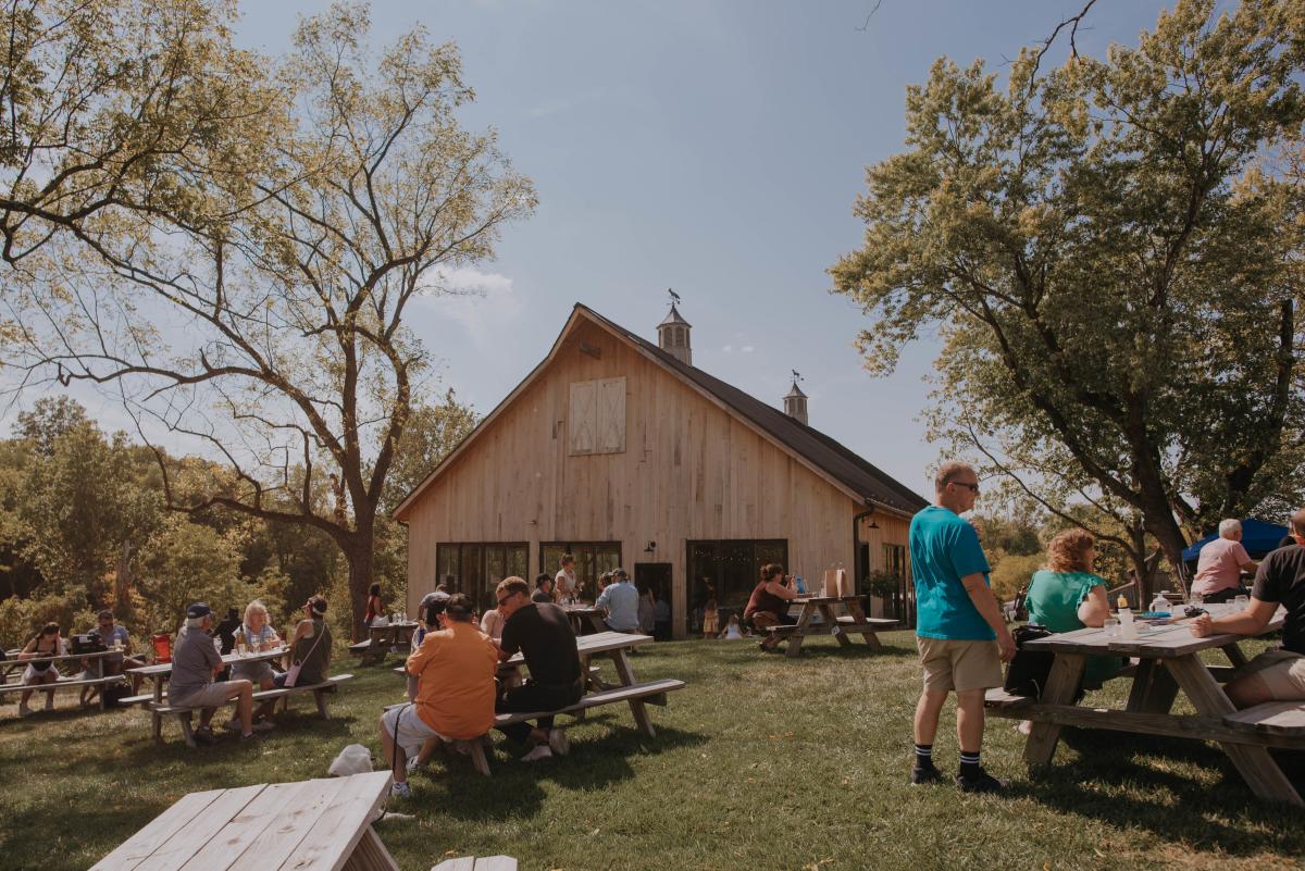 Visitors at picnic tables on the lawn outside the barn tasting room at Old Farm Winery in Loudoun