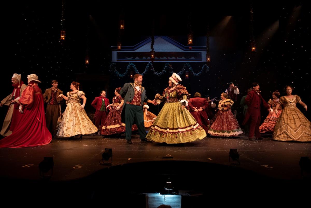 Couples dance onstage during a performance of A Christmas Carol at the Omaha Community Playhouse.