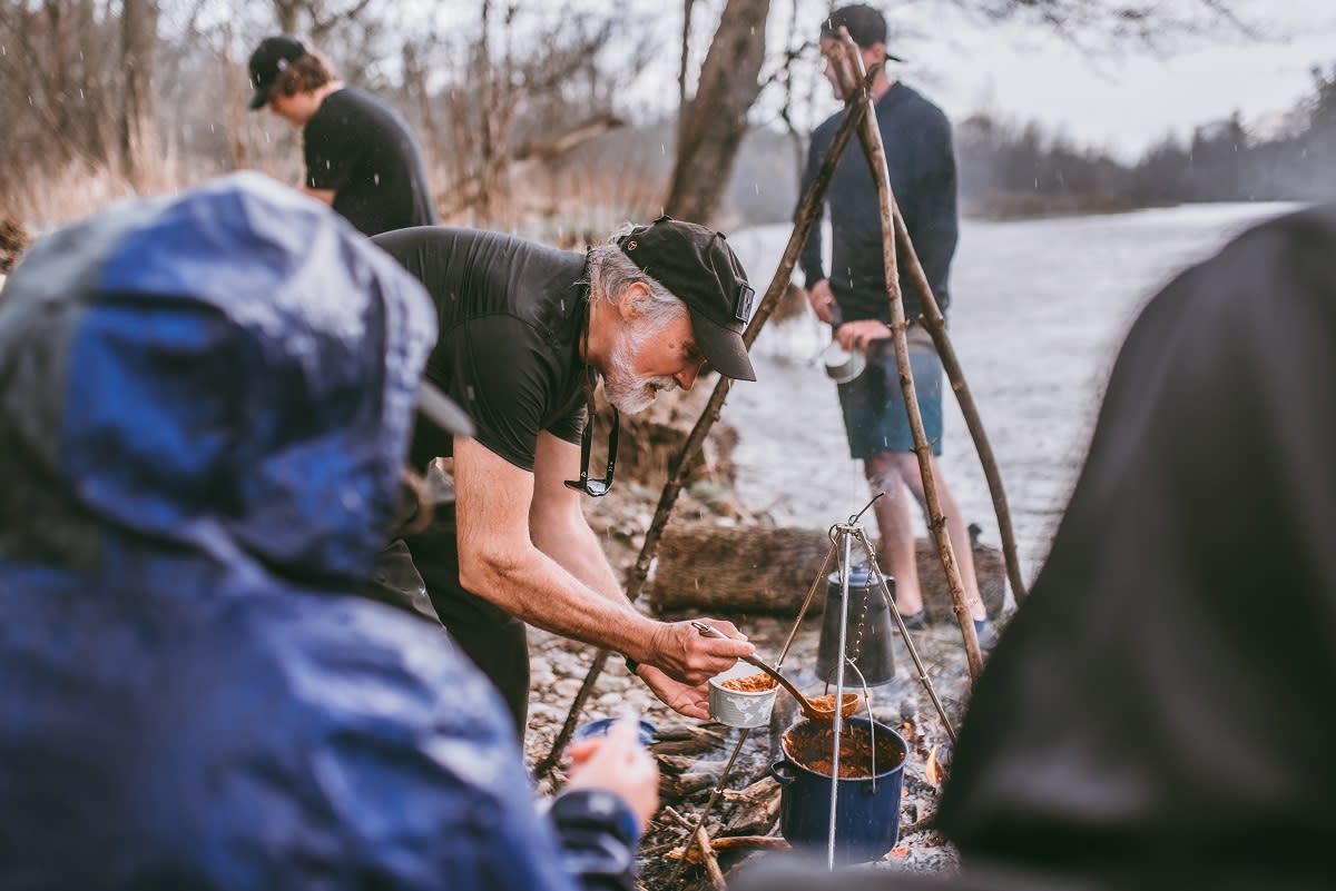 Men eating next to the river