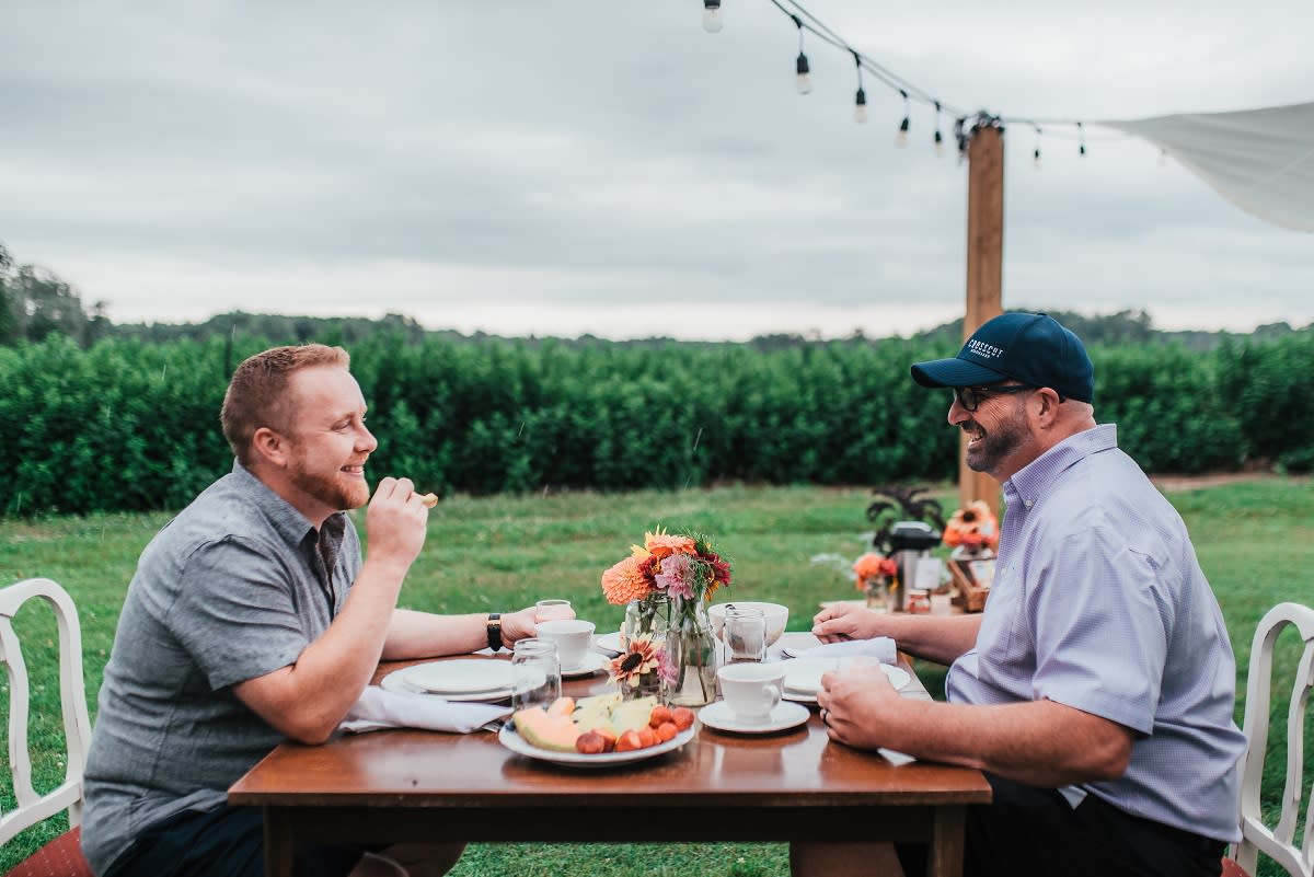 2 men eating outdoors at Thames River Melons