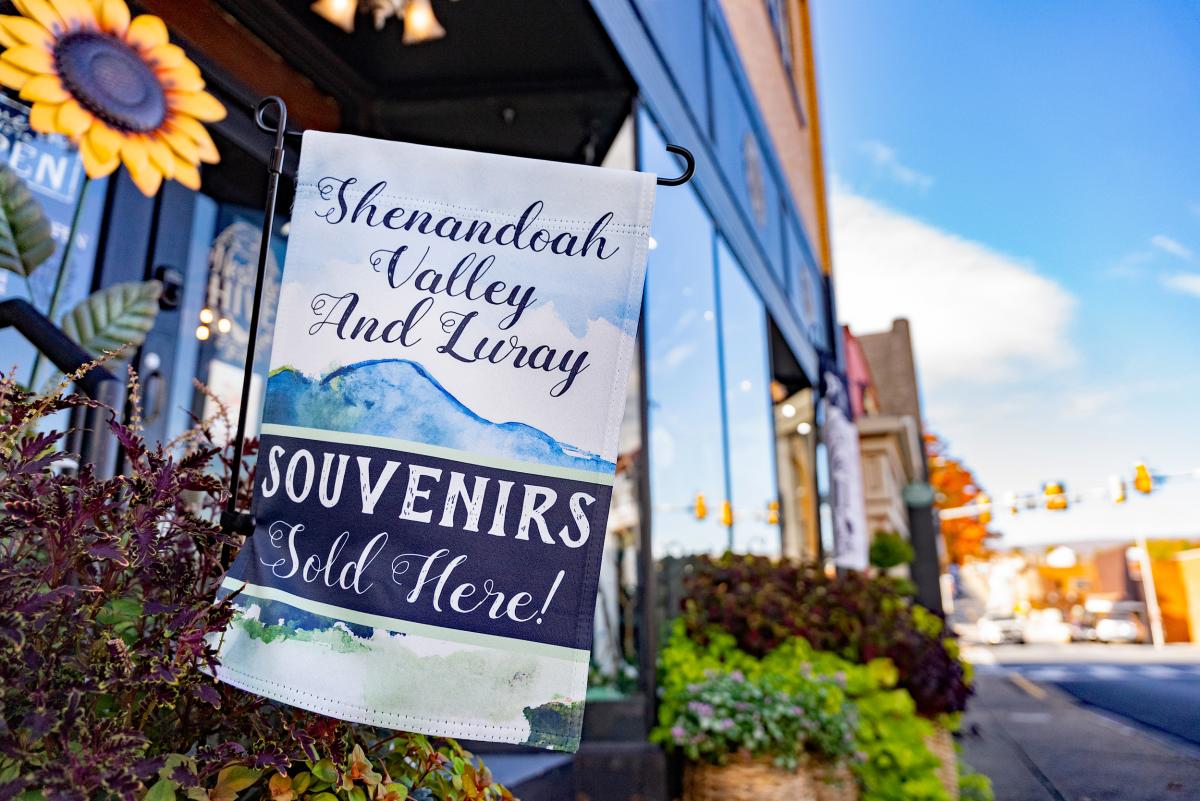 Shenandoah Valley and Luray souvenirs garden flag outside store with sunflower and sunny streetscape
